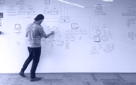 Andrés Rigo draws in a white board an information arquitecture map for a website project