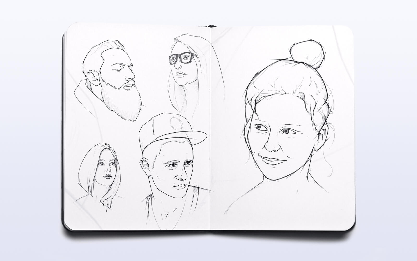 A sketchbook displaying a collection of lively sketches of people, highlighting their expressions and dynamic poses
